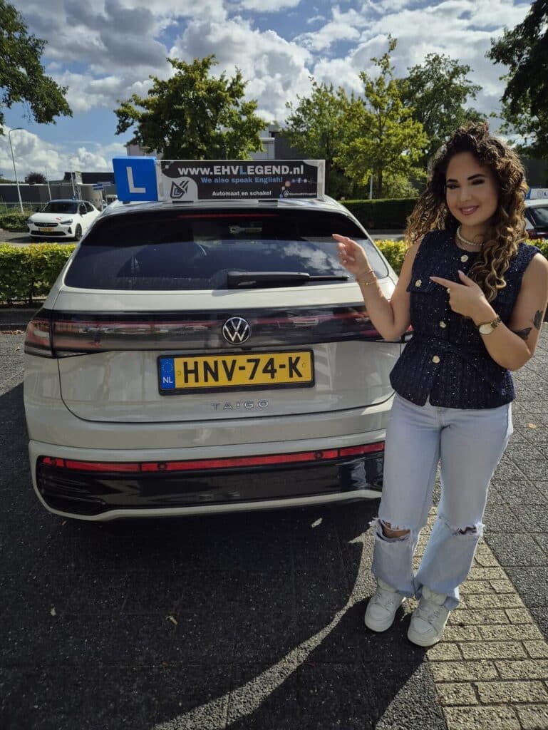 Geslaagde leerling poseert trots bij Volkswagen Taigo lesauto van rijschool EHVLegend in Eindhoven Geslaagde leerling poseert trots bij Volkswagen Taigo lesauto van rijschool EHVLegend in Eindhoven