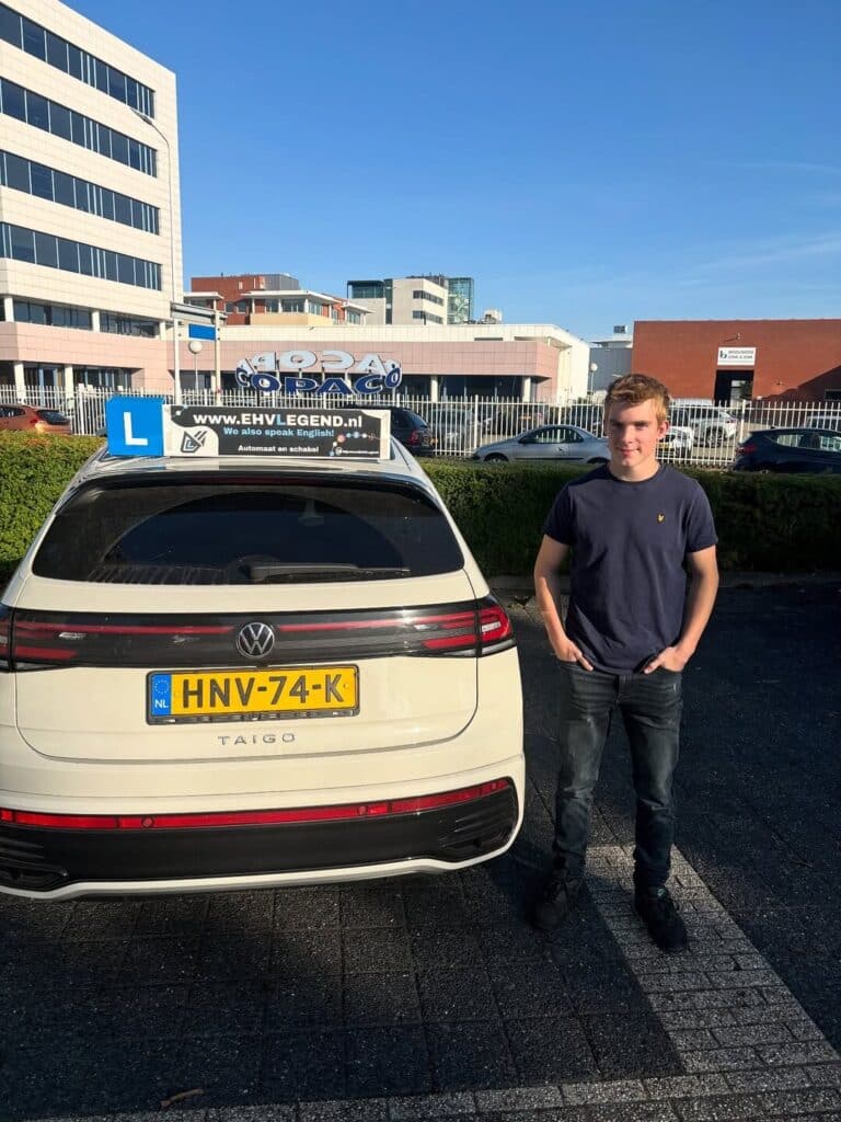 Geslaagde leerling staat trots naast lesauto van Rijschool EHVLegend in Eindhoven Geslaagde leerling staat trots naast lesauto van Rijschool EHVLegend in Eindhoven