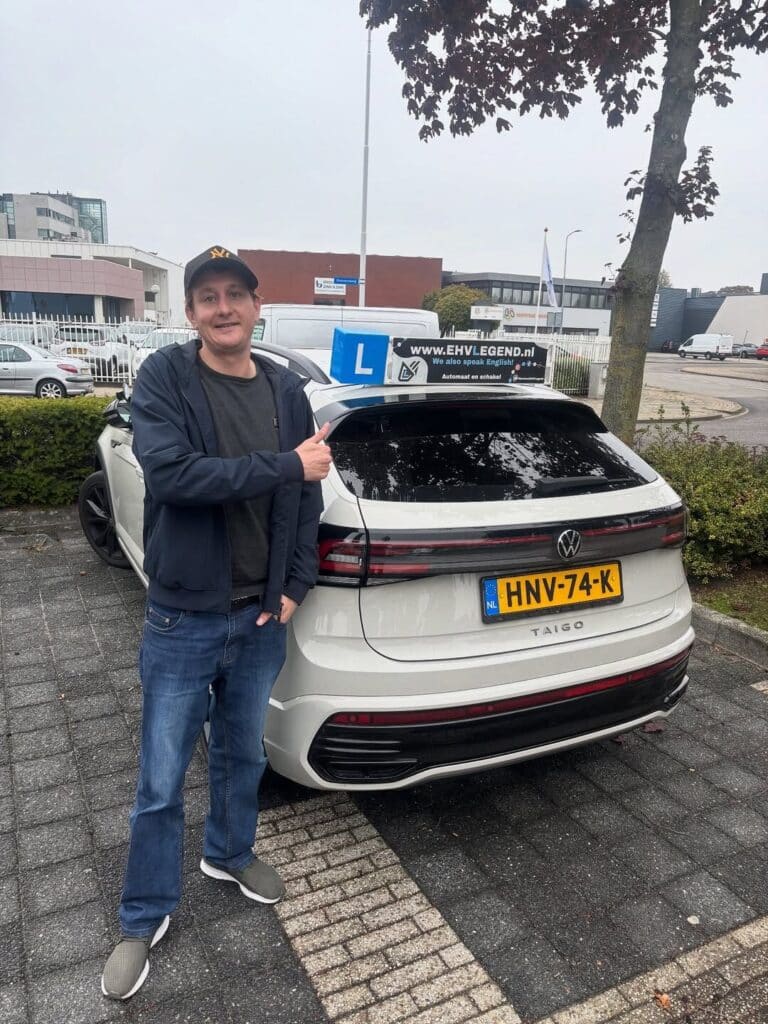 Geslaagde leerling van Rijschool EHVLegend poseert trots bij lesauto na het behalen van rijbewijs Geslaagde leerling van Rijschool EHVLegend poseert trots bij lesauto na het behalen van rijbewijs