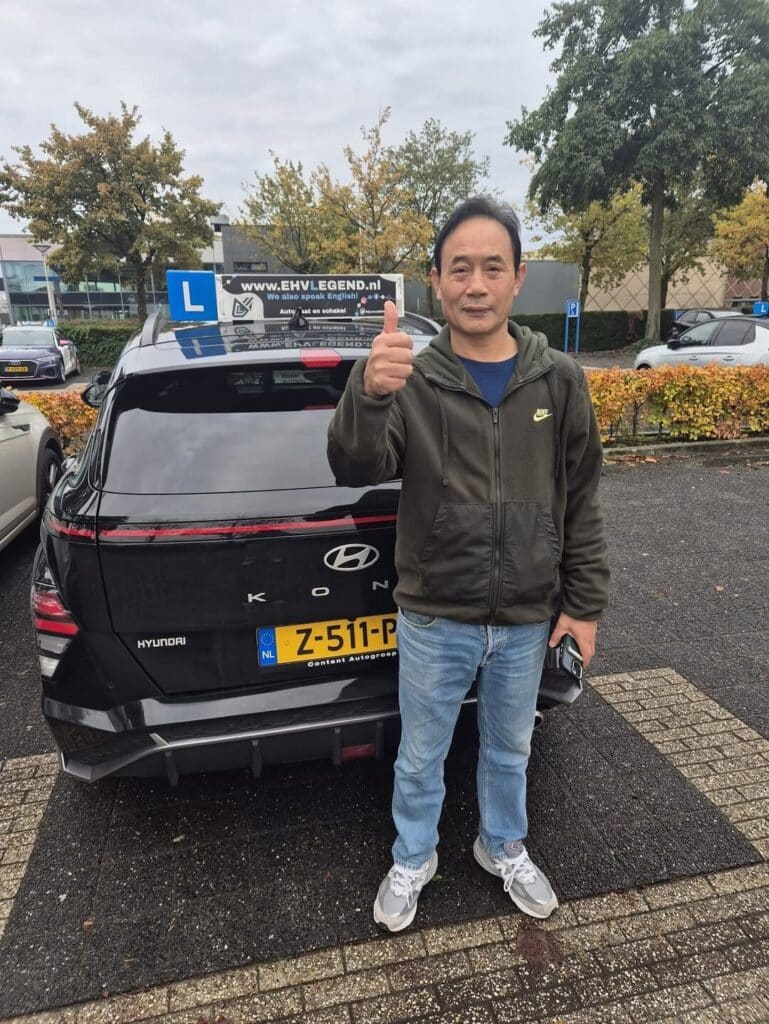 Geslaagde rijleerling toont duim omhoog bij Hyundai lesauto van Rijschool EHVLegend in Eindhoven Geslaagde rijleerling toont duim omhoog bij Hyundai lesauto van Rijschool EHVLegend in Eindhoven