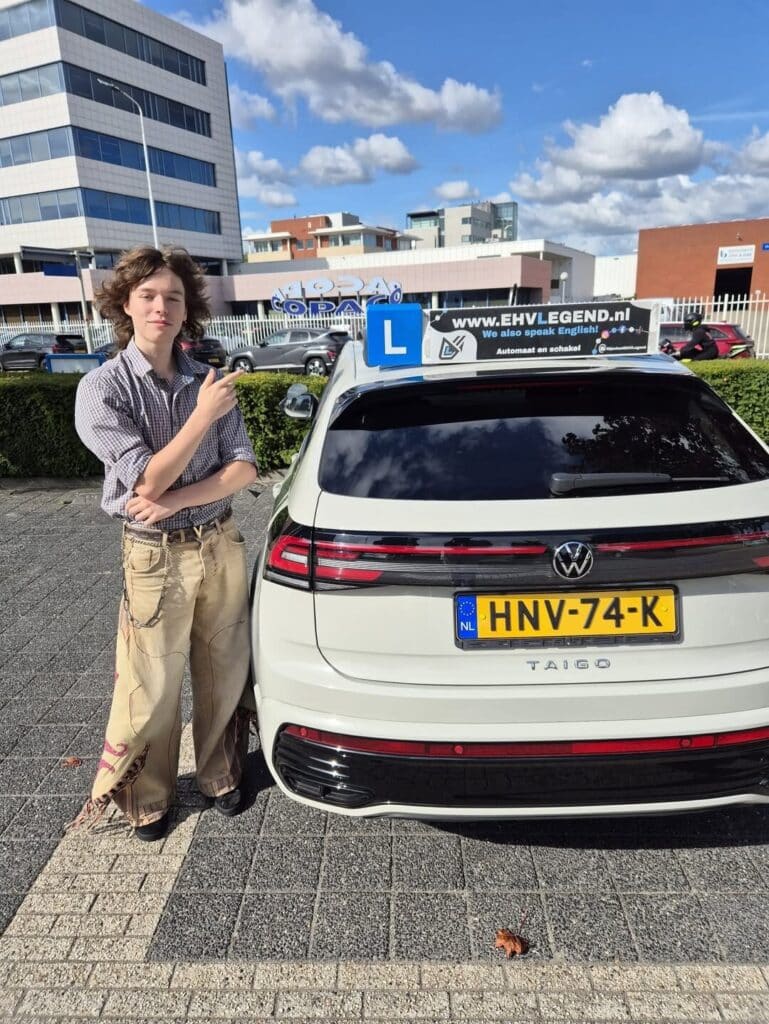 Geslaagde student poseert trots naast lesauto van Rijschool EHVLegend in Eindhoven Geslaagde student poseert trots naast lesauto van Rijschool EHVLegend in Eindhoven