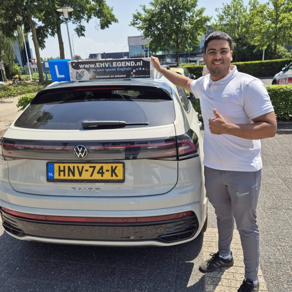 Geslaagde student van Rijschool EHVLegend poseert trots naast lesauto met L-bord in Eindhoven Geslaagde student van Rijschool EHVLegend poseert trots naast lesauto met L-bord in Eindhoven